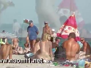Naomi1 paja un joven muchacho en un público playa